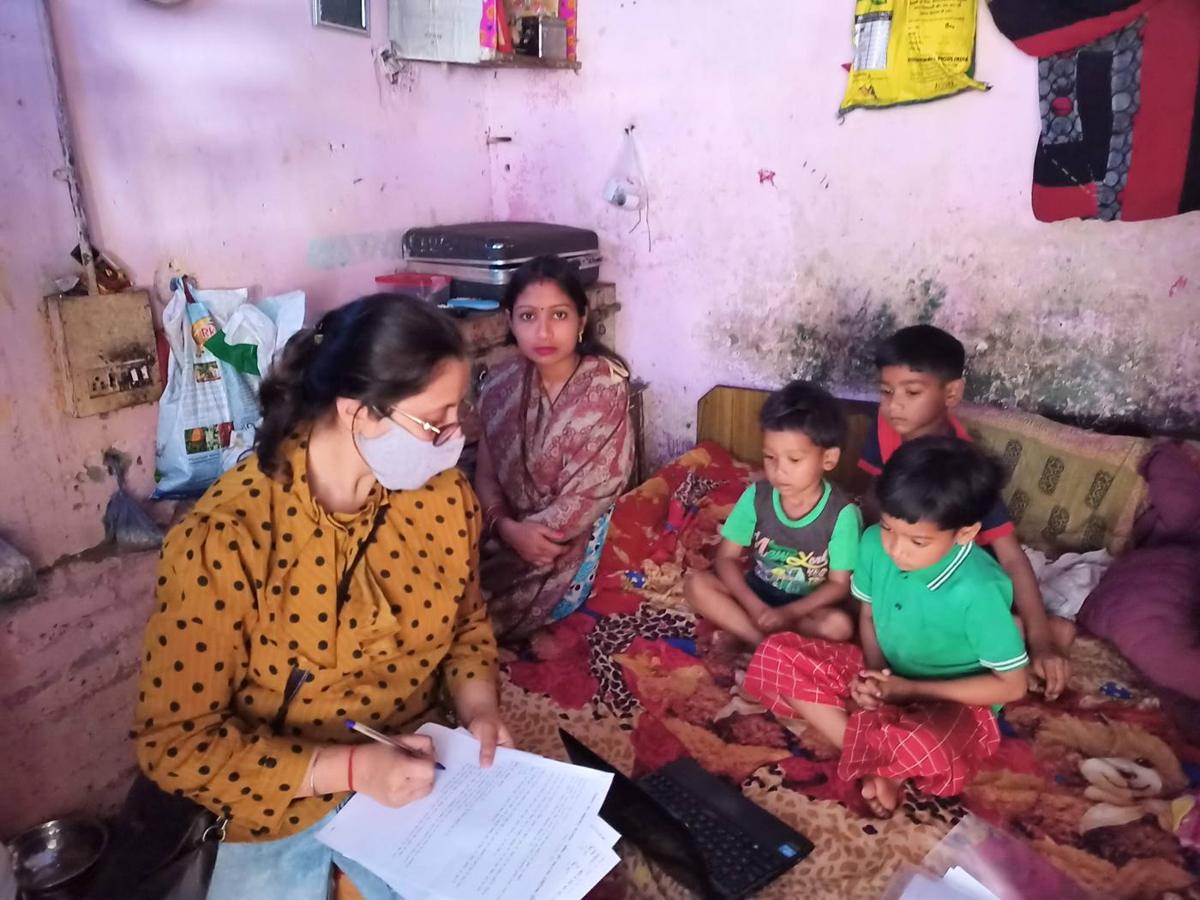 A researcher interviewing a mother with her children at home