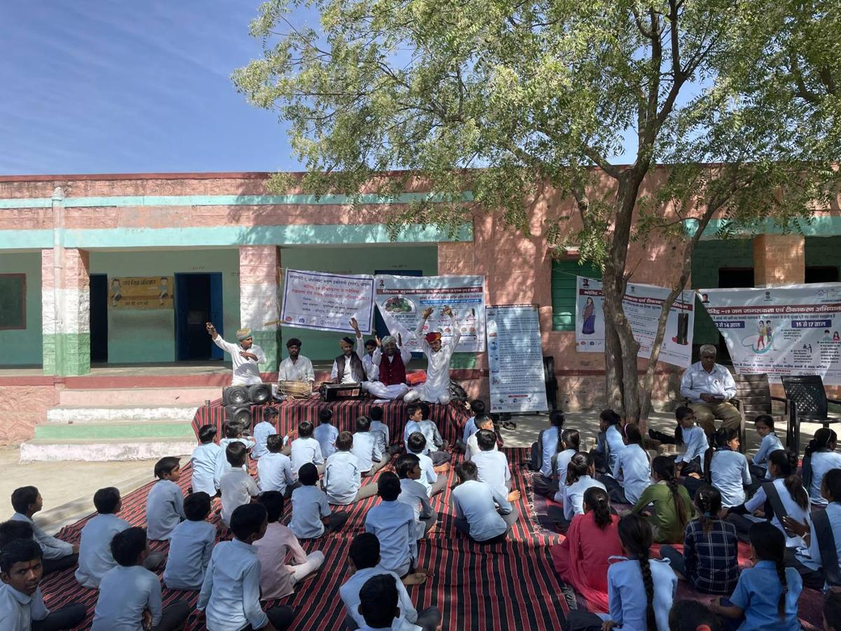 Students seated outside a school for a session